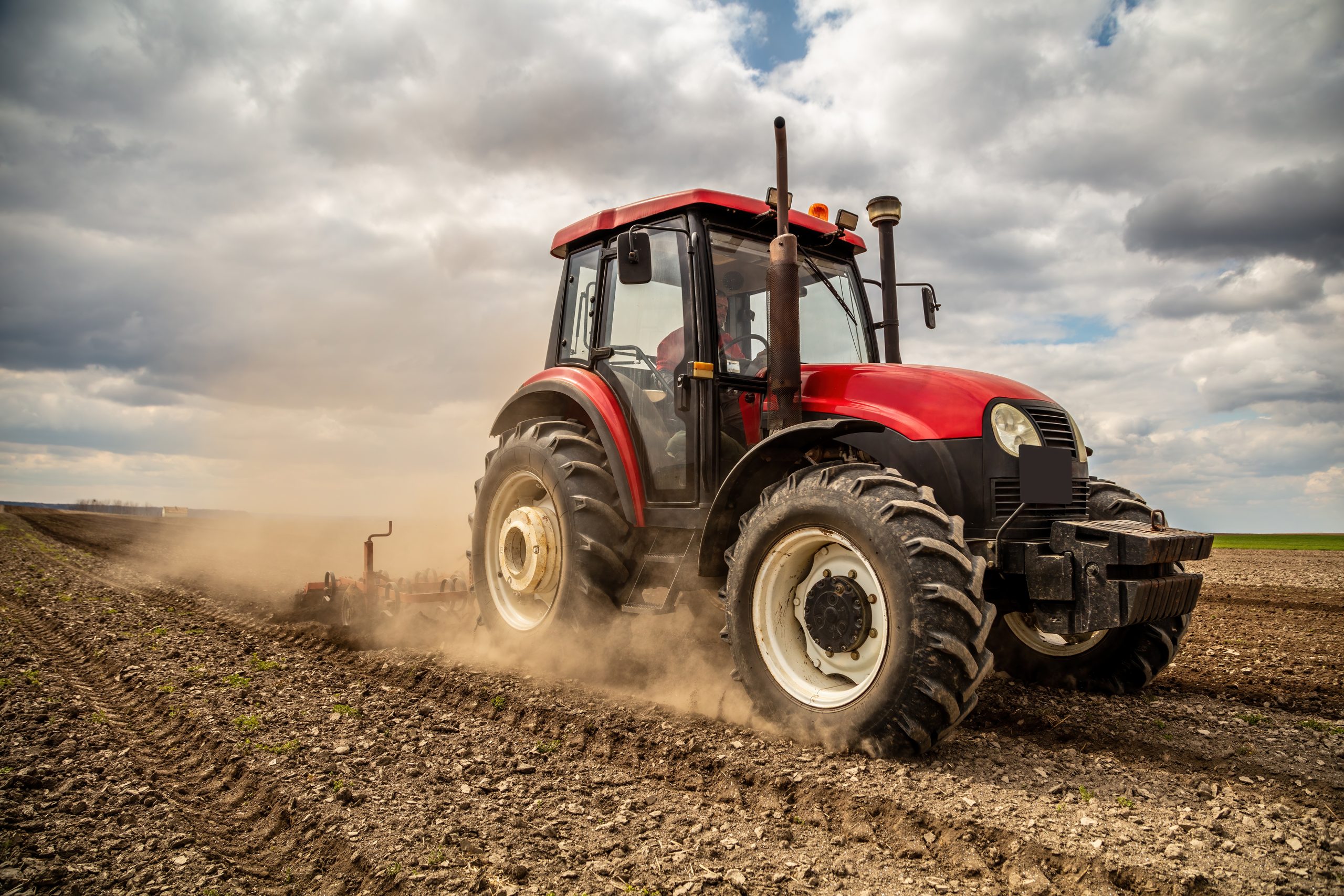 A tractor plowing the soil of a farmland field.