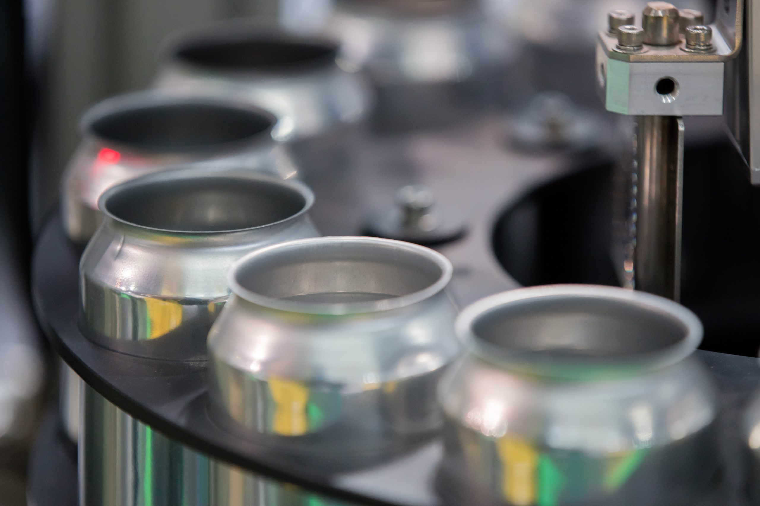 Aluminum cans being transferring on a factory conveyer belt.