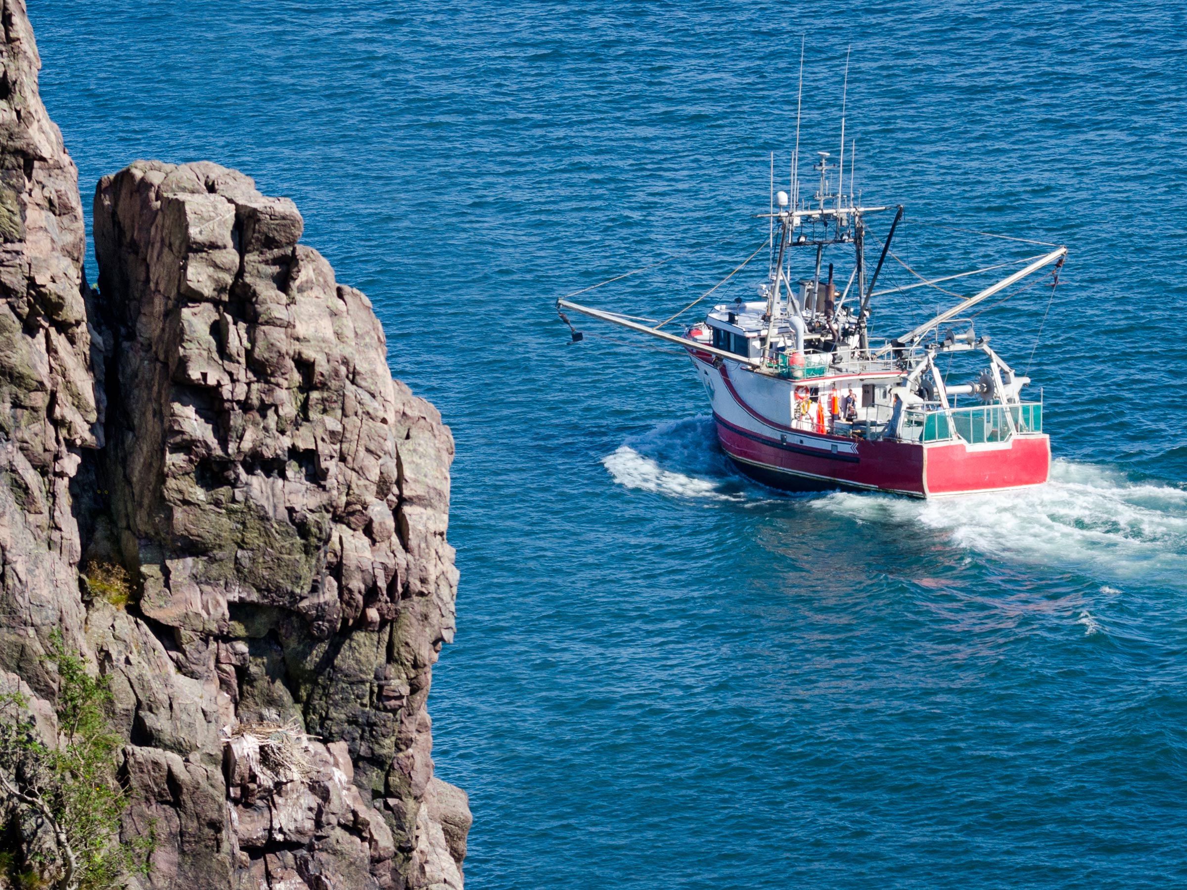 A fishing vessel sailing across the water.