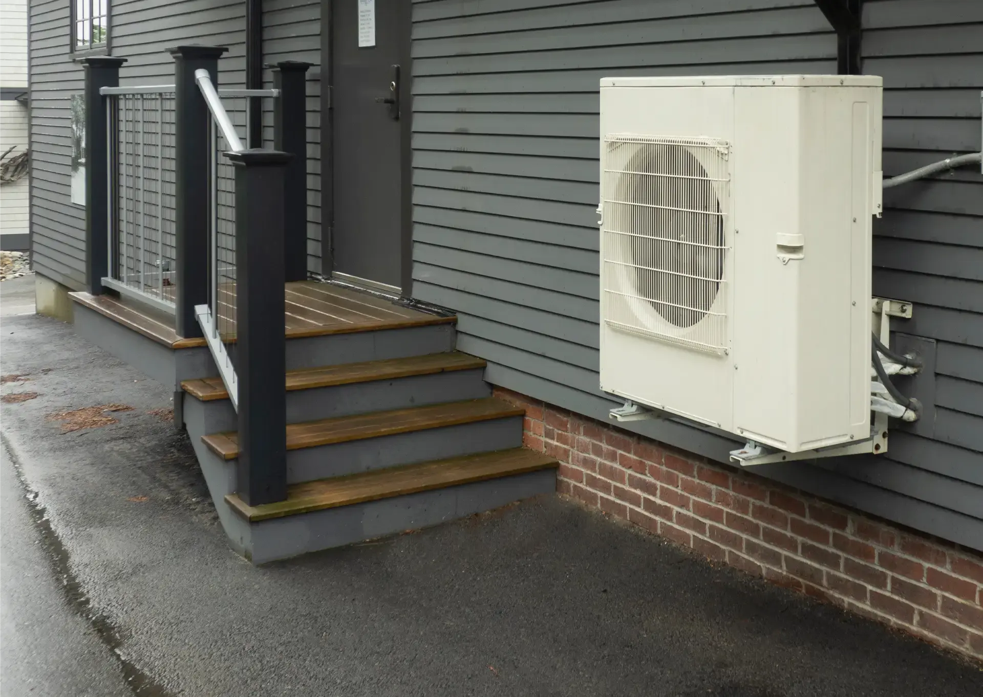 Outdoor HVAC unit attached to the siding of a residential home