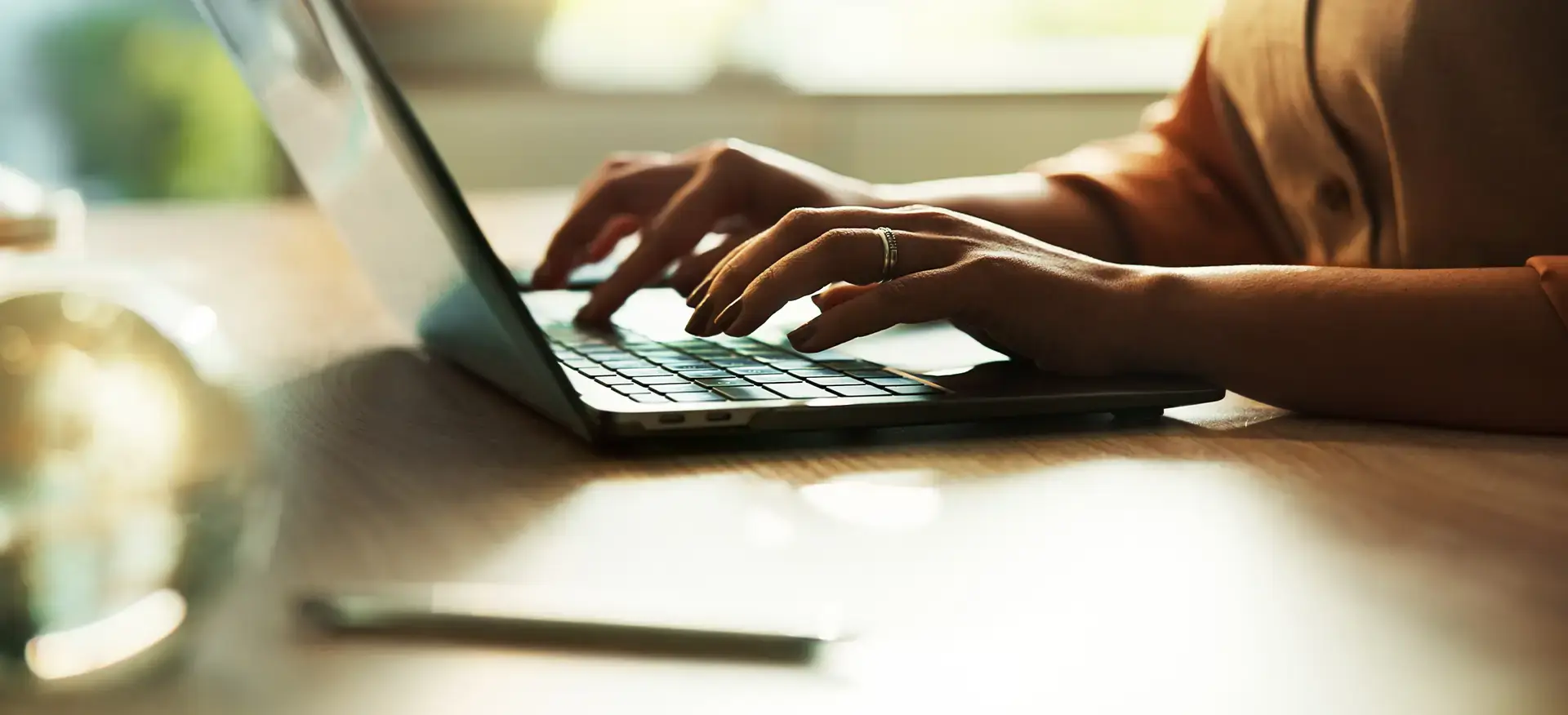 Closeup of a person's hands typing on a laptop.